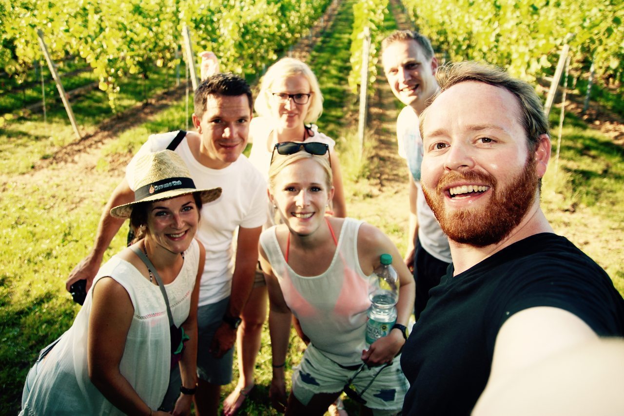 Friends in the German Wine Country walking through a vineyard.