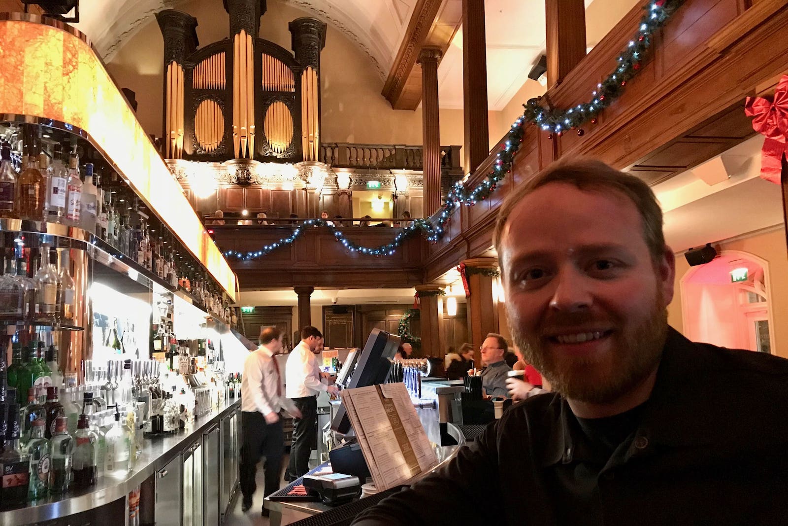 Judson sits waits for a drink at the Church Bar in Dublin Ireland. The Church's organ pipes are in the background.