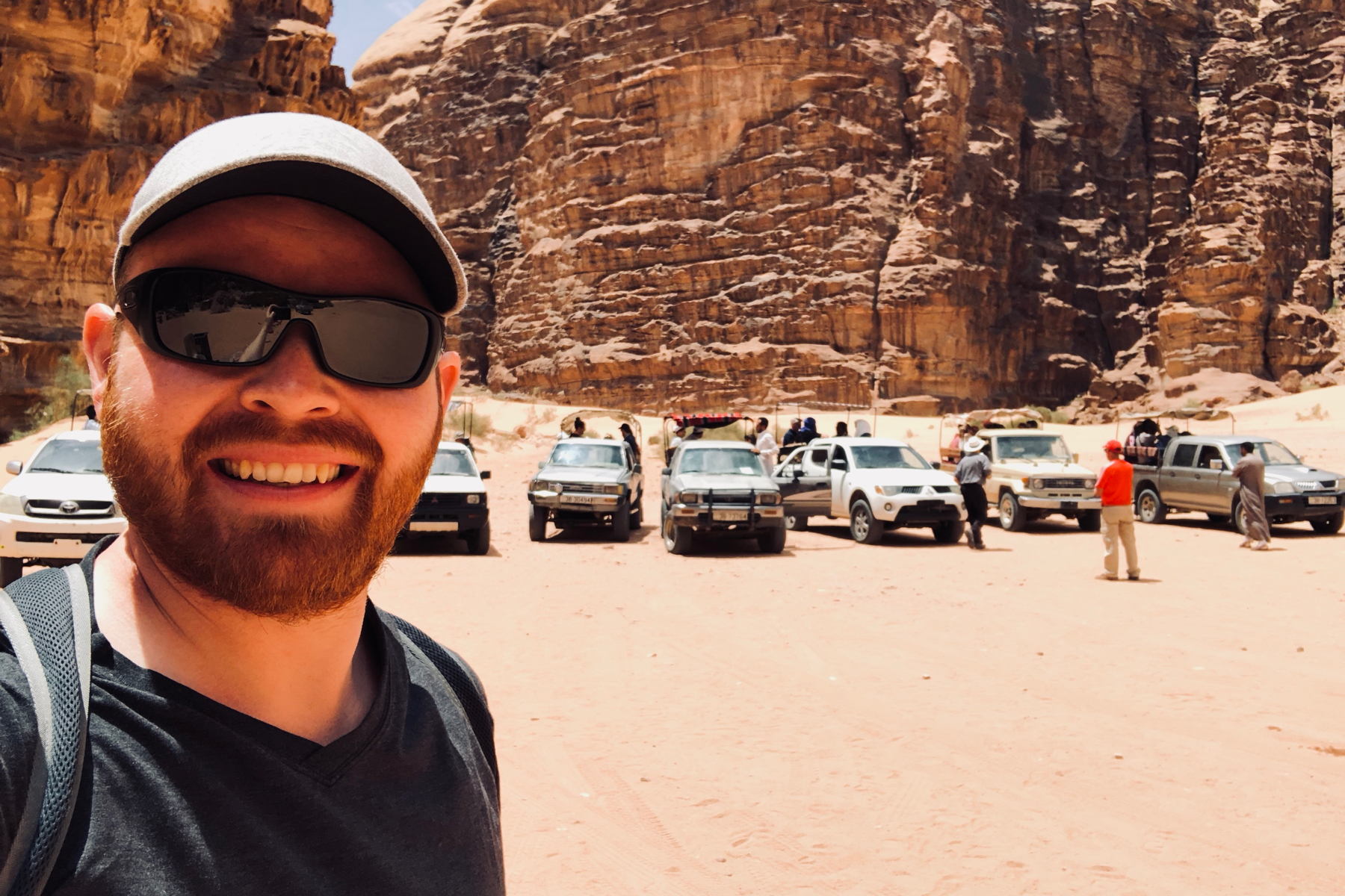 Judson poses with Wadi Rum tour jeeps in the Lawrence Memorial Bedouin Camp